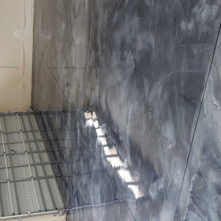 Metallic epoxy garage floor in gray and silver tones with marbled pattern and high-gloss reflective finish