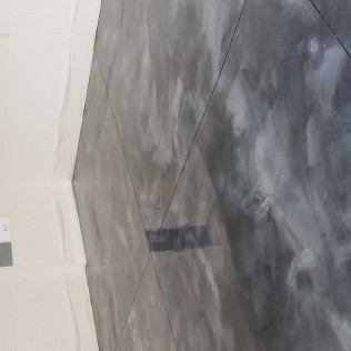 Diagonal view of metallic epoxy garage floor with cloudy gray finish and visible expansion joints