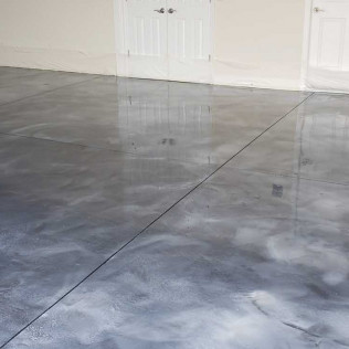 Wide angle view of metallic epoxy flooring in empty garage with seamless gray marble effect and expansion joints