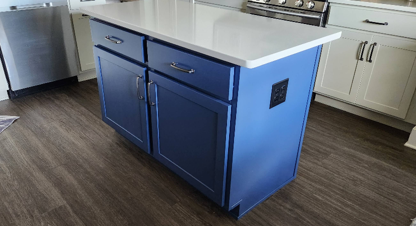 Kitchen island painted in blue with white countertop, white perimeter cabinets and modern hardware