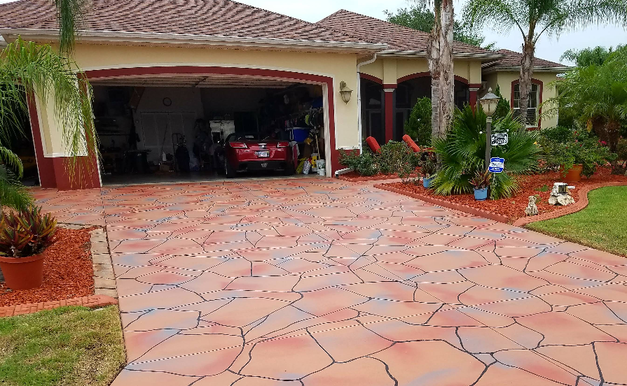 Decorative stamped and painted concrete driveway in terracotta tones with flagstone pattern