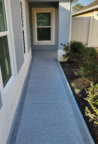 Gray speckled painted concrete side entrance walkway with decorative border pattern