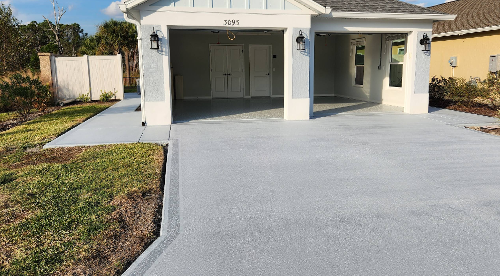 White painted home with two-car garage showing light gray epoxy floor coating and painted driveway