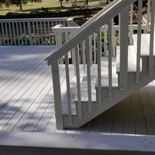 White painted deck stairs with railing showing detailed craftsmanship and smooth painted finish