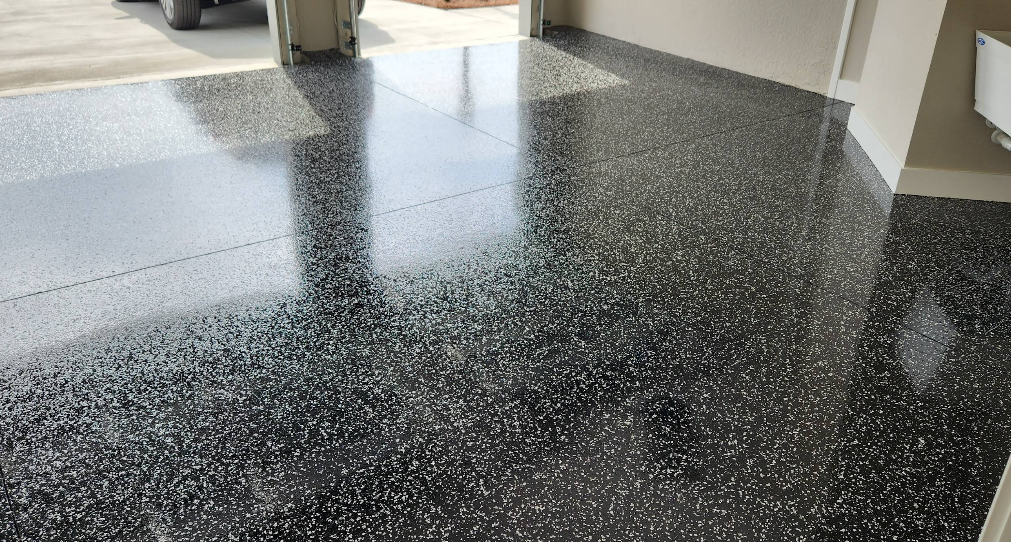 High-gloss black and gray speckled epoxy garage floor with reflective finish in modern home