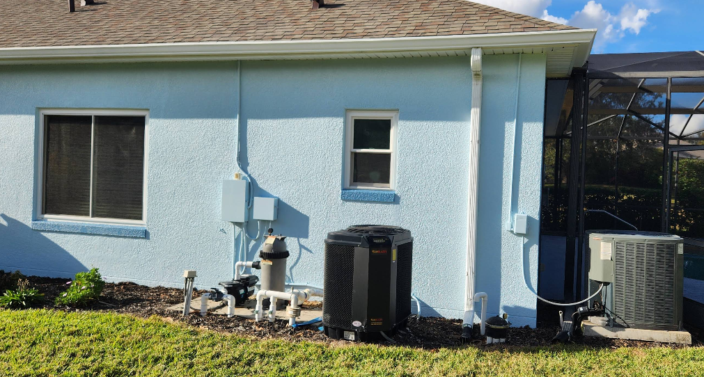 Home exterior painted in light blue with white trim and HVAC units on side yard