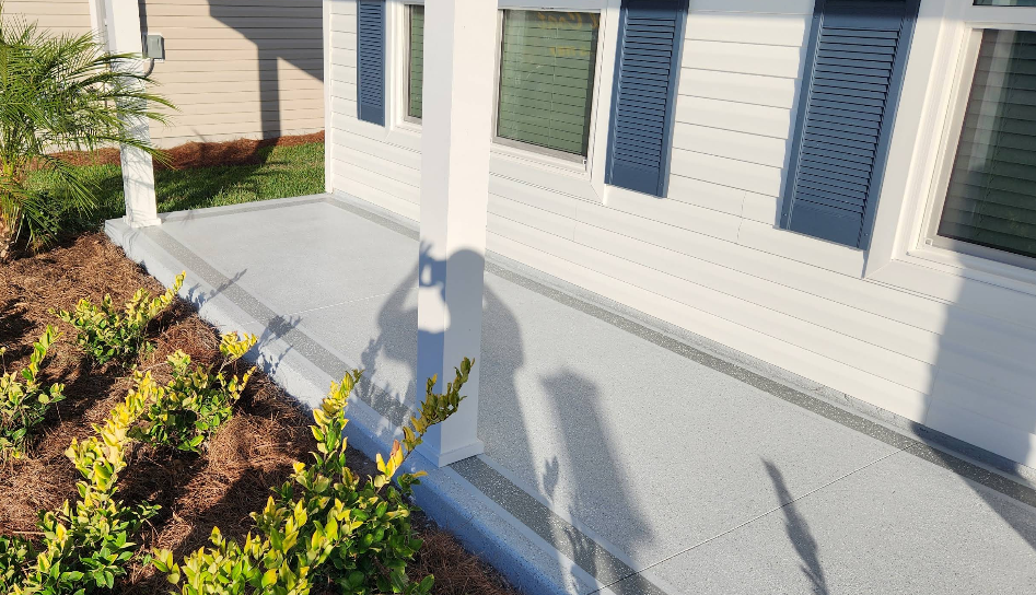 Light gray painted concrete porch and steps at white painted home with blue shutters and fresh landscaping