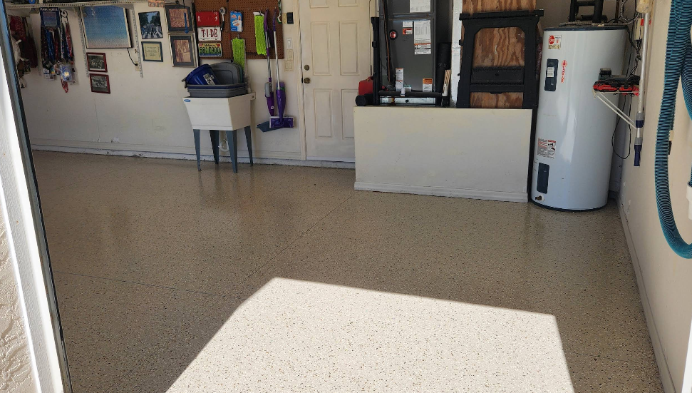Residential garage interior with tan speckled epoxy floor coating and organized storage