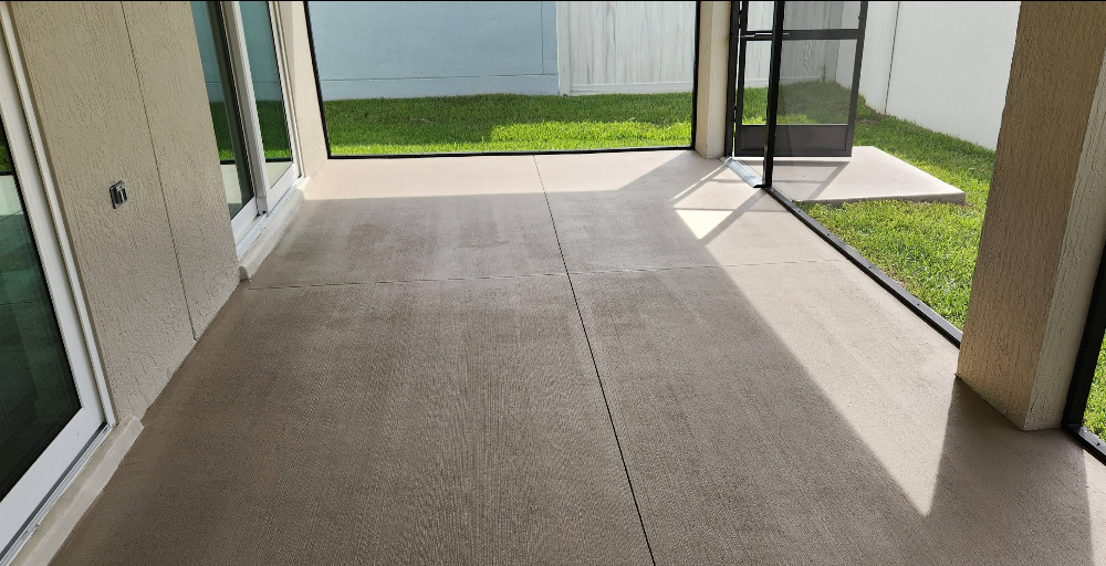 Screened patio with light beige painted concrete floor overlooking pool area and backyard